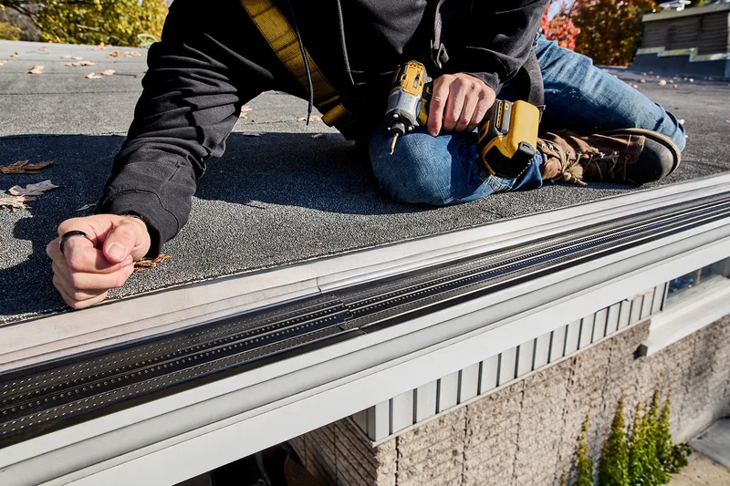 Technician repairing a leaking gutter seam